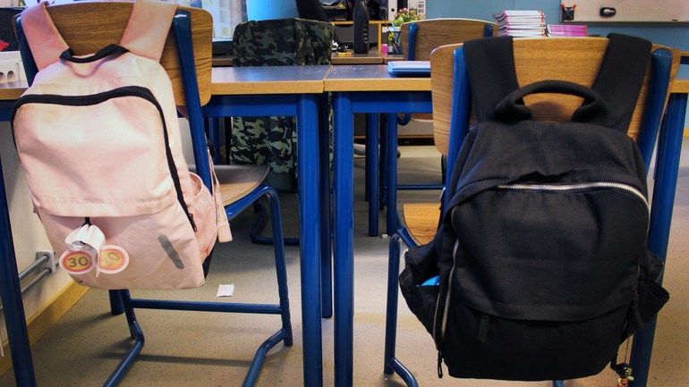 Närbild ryggsäckar i klassrum.