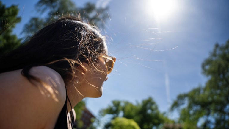 Kvinna i park och sol på himmelen
