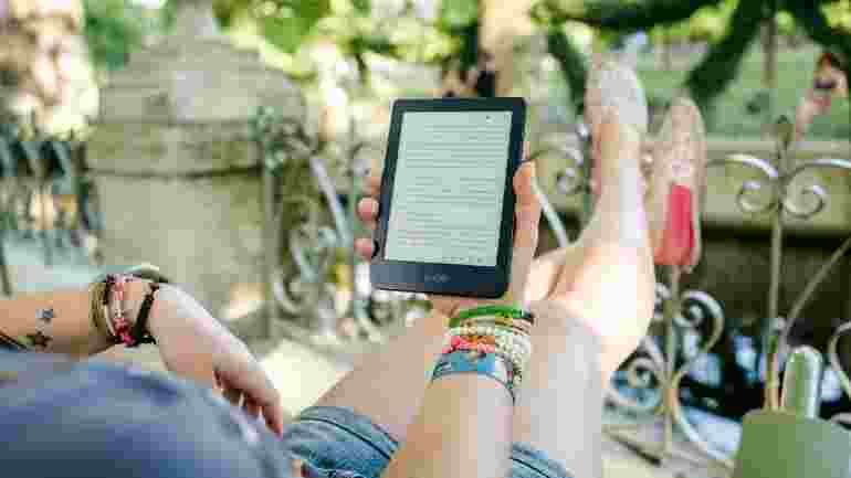 woman lying down and relaxing with an e-reader device