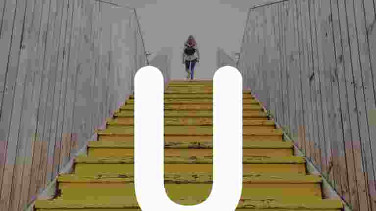 Unic network logo and person walking up stairs.