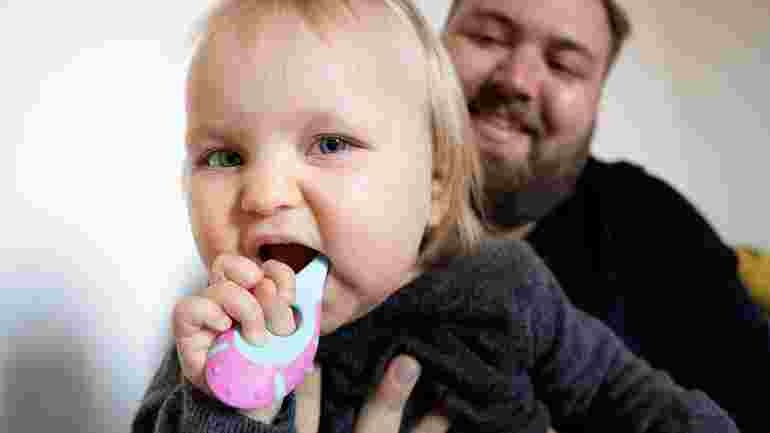 Förälder och småbarn borstar tänderna.