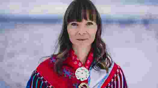 Ann-Helene i ett snölandskap iklädd samisk folkdräkt