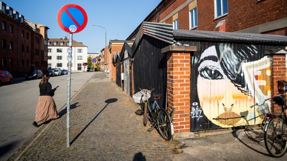 En person som går längs en gata bredvid en byggnad.