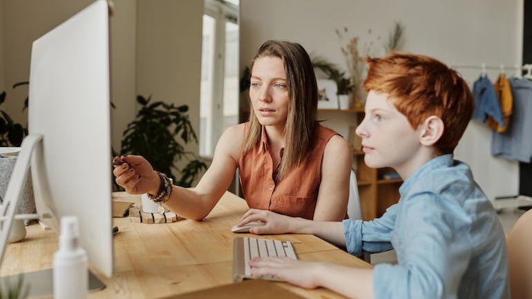Photo shows pupil and teaxcher at a computer