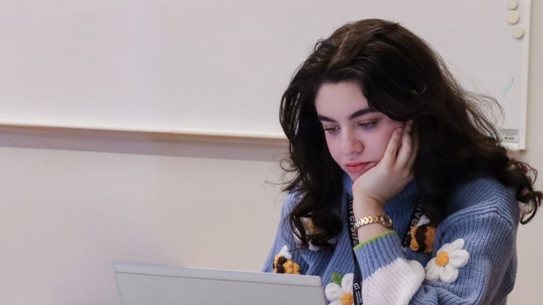 Person som sitter vid datorn och tittar på den.