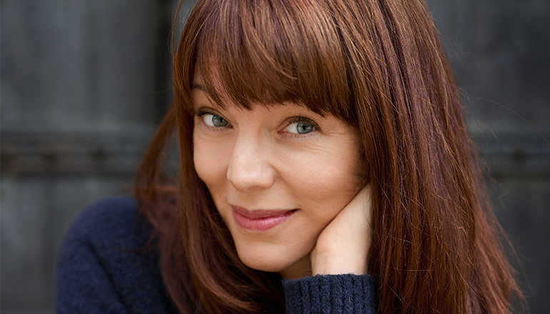 Lina Wolff in a blue knit sweater.