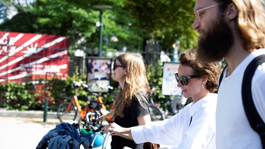 Students walking with bike in summer.