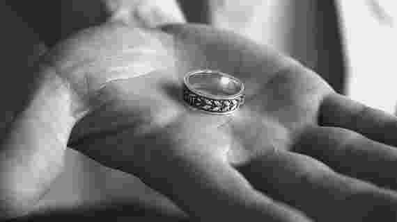 Hand holding the doctoral ring. Black and white photo.