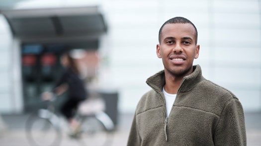 Porträttbild på student i stadsmiljö.