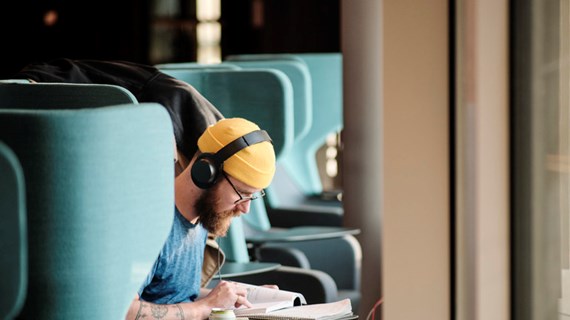Student studerar framför fönster.