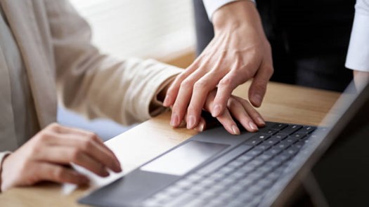 Unwelcomed hand on someone typing on a computer