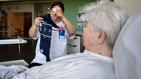 Sjuksköterska tar blodtryck på äldre patient.