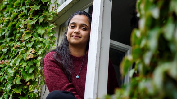 Alumn tittar in i kameran och ler