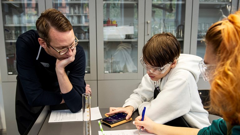 Lärare pratar med elev under NO-lektion.
