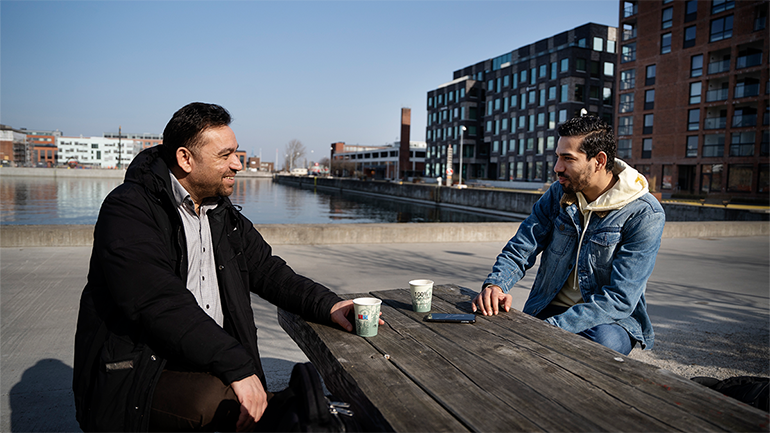 Två personer som sitter ute och pratar